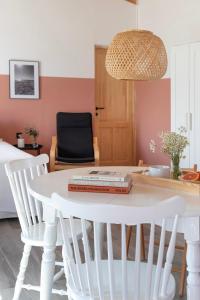 uma mesa branca com duas cadeiras e uma mesa com livros sobre ela em House on the Sand close to Olympia em Katakolo