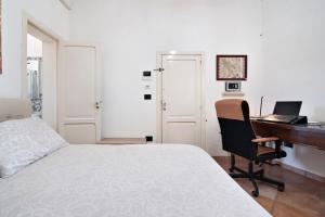 een slaapkamer met een bed, een bureau en een computer bij The golden hour, luxury apartment with a panoramic view in Lecce