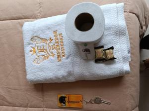 uma toalha e um rolo de papel higiénico numa cama em HOSPEDAJE EL EMPERADOR CAJAMARCA em Cajamarca