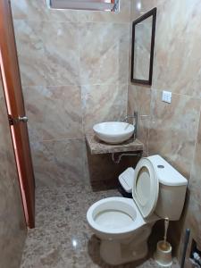 y baño con aseo y lavamanos. en HOSPEDAJE EL EMPERADOR CAJAMARCA, en Cajamarca