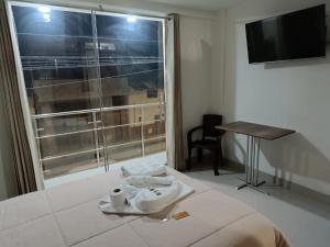 カハマルカにあるHOSPEDAJE EL EMPERADOR CAJAMARCAのベッドと窓が備わるホテルルーム