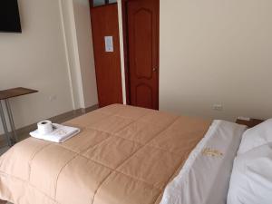Una cama con una toalla encima. en HOSPEDAJE EL EMPERADOR CAJAMARCA, en Cajamarca