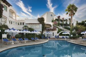 a hotel with a swimming pool with chairs and umbrellas at Hotel Continental Ischia in Ischia