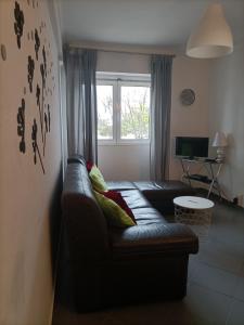 uma sala de estar com um sofá de couro e uma janela em AU COEUR D'OLHAO em Olhão