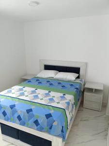 a bedroom with a bed with a blue and white comforter at Apartamento Flandes in Flandes