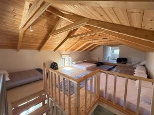 een zolderkamer met 2 bedden en een trap bij Natural Retreat Shelter #Unoblu® 