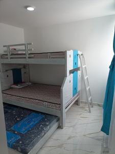 two bunk beds in a room with a ladder at Apartamento Flandes in Flandes
