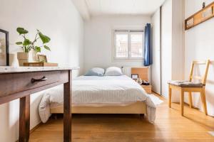 een slaapkamer met een bed, een tafel en een raam bij Stud SDB perso et taxi CDG extra in Aulnay-sous-Bois
