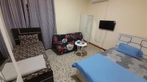 Un dormitorio con una cama, una silla y un sofá. en Admf#101, en Abu Dabi