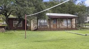 a house with a pole in front of a yard at Thunderbird Lodge in Burnet