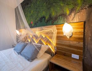 a bedroom with a bed with a mosquito net on it at Ambos Mundos Hotel Boutique in Taganga