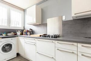 a kitchen with white cabinets and a washing machine at Chbre 2 pers, sdb privée, repas et Taxi CDG Extra in Aulnay-sous-Bois +15 photos