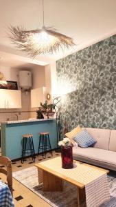 ein Wohnzimmer mit einem Sofa und einem Tisch in der Unterkunft Le Petit Catalan in Marseille