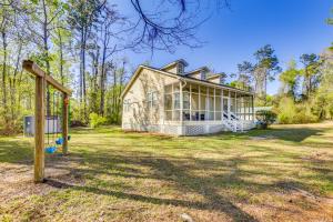 une maison sur une cour herbeuse avec une aire de jeux dans l'établissement Bainbridge Home with Cove and Lake Seminole Access!, à Bainbridge