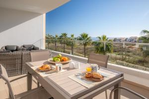 a table with food on a balcony with a view of the ocean at Casa Lilou - Luxury Oceanview Penthouse in Lagos