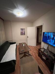 ein Wohnzimmer mit einem Sofa, einem Tisch und einem TV in der Unterkunft Friendly home 2 in Tuzla