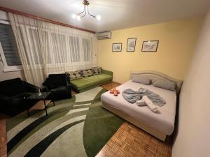 ein kleines Schlafzimmer mit einem Bett und einem Sofa in der Unterkunft Friendly home 2 in Tuzla
