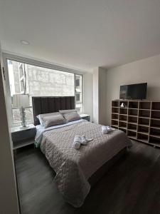 a bedroom with a large bed and a large window at Hermoso apartamento, capacidad 8 personas in Pasto