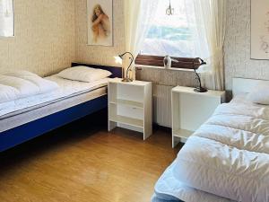 a bedroom with two beds and a window at Holiday home Svanesund VI in Svanesund