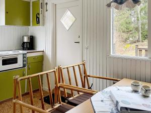 eine Küche mit einem Tisch, einem Tisch und einem Fenster in der Unterkunft Holiday home Norrtälje IV in Norrtälje