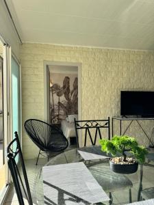 ein Wohnzimmer mit einem Tisch und einem TV in der Unterkunft Ti kaz'la in Martigues