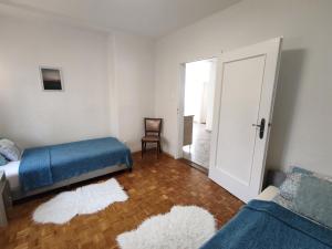 1 dormitorio con 2 camas y puerta con silla en Villa Vonyarc, en Vonyarcvashegy