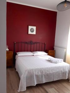 1 dormitorio con 1 cama con pared roja en B&B l'Eucalipto, en Martina Franca