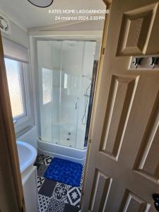 a bathroom with a shower and a toilet and a door at Kates Home Lagganhouse Woodland Way 19 in Ballantrae