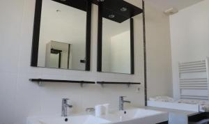 a bathroom with two sinks and a large mirror at L'Olivier in Montoison