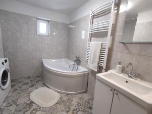 Baño blanco con bañera y lavamanos en Villa Vonyarc, en Vonyarcvashegy