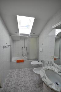 a bathroom with a sink and a toilet and a skylight at Residence Sonnenburger in Parcines