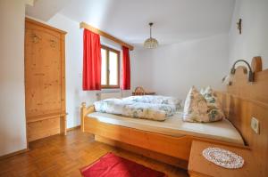 a bedroom with a bed and a red window at Residence Sonnenburger in Parcines