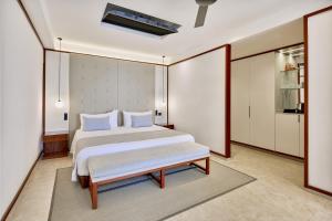 1 dormitorio con cama y banco. en Live Aqua Punta Cana - All Inclusive - Adults Only, en Punta Cana