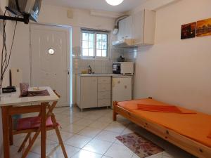a kitchen with a bed and a table in a room at Ανεξάρτητη γκαρσονιέρα κοντά στο κέντρο της Πάτρας in Patra