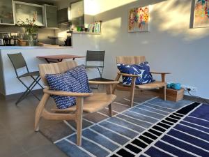 a living room with two chairs and a table at LE CAP - bungalow vue mer et colline - Hauteur de Cassis in Cassis