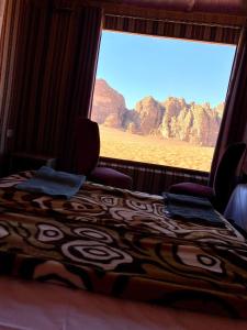 a bedroom with a bed and a window with a view at Rum Marriott luxury camp in Wadi Rum