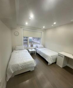 a bedroom with two beds and a clock on the wall at Modern Luxury 3 bed rooms House in Toronto Mississauga in Mississauga