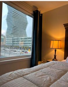 een slaapkamer met een raam met uitzicht op een gebouw bij Modern Luxury 3 bed rooms House in Toronto Mississauga in Mississauga