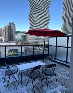 a table and chairs with an umbrella on a balcony at Modern Luxury 3 bed rooms House in Toronto Mississauga in Mississauga