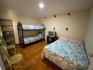 1 dormitorio con 1 cama y 1 litera en La casa de los Viajeros, en Huarmey
