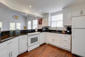 a white kitchen with white appliances and wooden floors at Villa Coastal by Brightwild-Pool & Free Parking in Key West
