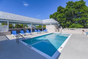 基韋斯特的住宿－Villa Coastal by Brightwild-Pool & Free Parking，一个带蓝色躺椅的游泳池和一个游泳池