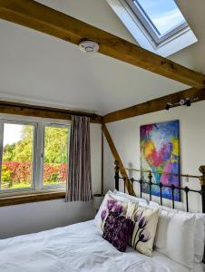 a bedroom with a bed and two windows at Romantic Barn, Private Hot-Tub near Diddly Squat 2 or 3 night stays in Chipping Norton