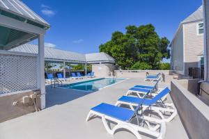a swimming pool with blue lounge chairs on a patio at Villa Coastal by Brightwild-Pool & Free Parking in Key West