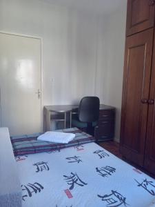 a bedroom with a bed and a desk and a chair at Apto central completo com garagem in Caxias do Sul