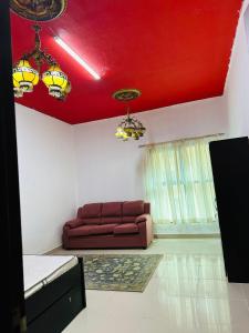 a living room with a red ceiling and a couch at Modern Comfort Fully Furnished Room for Rent in Ajman 
