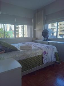 a bedroom with a bed and a large window at Apto central completo 3 dormitórios in Caxias do Sul