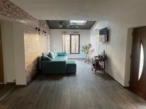 澤巴拉的住宿－Casa bunicilor/ Grandparent’s house，带沙发和砖墙的客厅