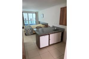 eine Küche mit einem Waschbecken und ein Zimmer mit einem Bett in der Unterkunft Blue Sunset in João Pessoa