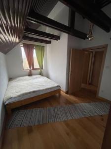 ein Schlafzimmer mit einem Bett in einem Zimmer mit einem Fenster in der Unterkunft Casa bunicilor/ Grandparent’s house in Zăbala
